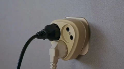 Electricity consumption - plugging power plugs into wall outlet. Time lapse Stock Footage 121341997