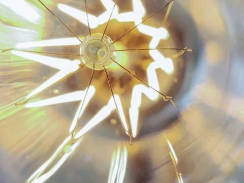 Electricity current inside a retro crystal clear light bulb. Stock Photos