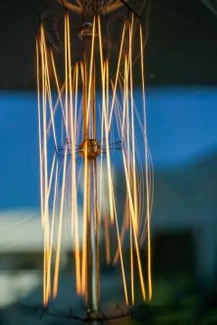 Electricity current inside a retro crystal clear light bulb. Stock Photos