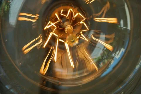 Electricity current inside a retro crystal clear light bulb. Stock Photos