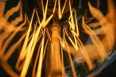 Electricity current inside a retro crystal clear light bulb. Stock Photos