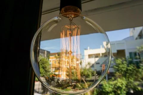 Electricity current inside a retro crystal clear light bulb. Stock Photos