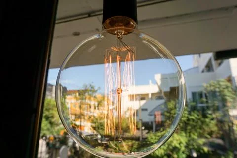Electricity current inside a retro crystal clear light bulb. Stock Photos