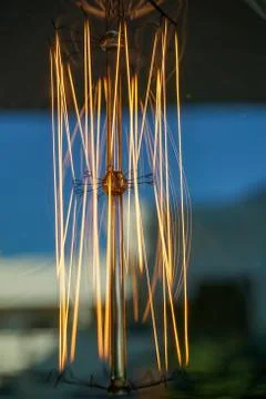 Electricity current inside a retro crystal clear light bulb. Stock Photos