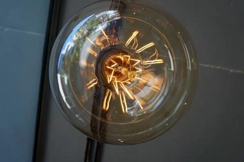 Electricity current inside a retro crystal clear light bulb. Stock Photos
