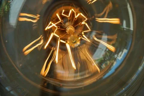 Electricity current inside a retro crystal clear light bulb. Stock Photos