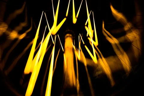 Electricity current inside a retro crystal clear light bulb. Stock Photos
