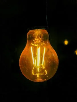 Electricity current inside a retro crystal clear light bulb. Stock Photos