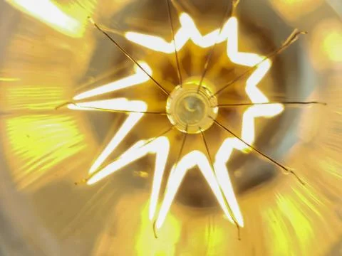 Electricity current inside a retro crystal clear light bulb. Stock Photos