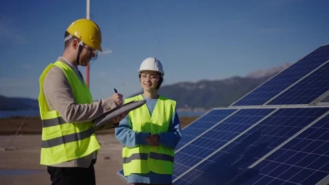 Electricity engineers checking solar panels array connection on digital tablet Stock Footage 289020256