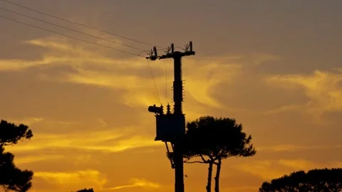 Electricity pole and transformer silhouette at golden sunset Stock Footage 344916883