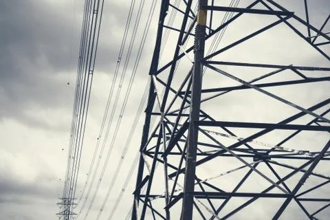 Electricity poles in the dark cloudy sky. Stock Photos