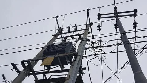 Electricity post on a cloudy day, close-up of electric wires Stock Photos