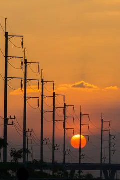 Electricity post in front of sunset background Stock Photos