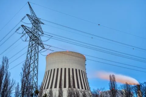 An electricity pylon and the smoke stack of a power station Stock Photos