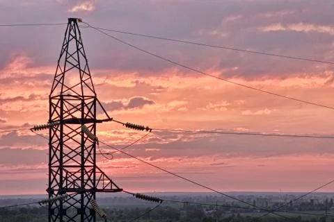 Electricity pylon on dramatic sunset sky background. Stock Photos