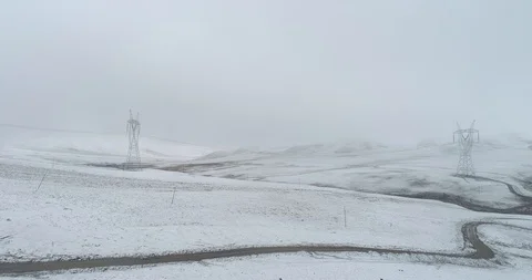 Electricity pylon on mountain which covered with snow Stock Footage 120350017
