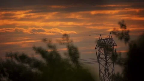 Electricity pylon with orange cloudy sky at sunset Stock Footage 154032136