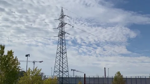 An electricity pylon with power lines and distant industrial elements. Stock Footage 320862900