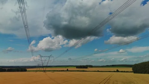 Electricity Pylon Standing in Wheat Field Under Cloudy Sky Stock Footage 307134099