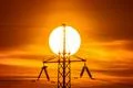 The electricity pylon with wire and hude sun background it Photo