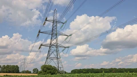Electricity pylons in a field with clouds and blue sky time lapse. 4k. UK Stock Footage 157602789