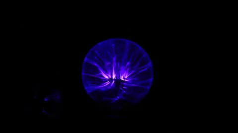 Electricity from a tesla coil based violet wand jumps to a small light bulb Stock Footage 46941933