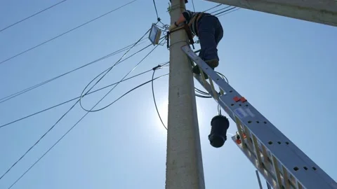 Electricity work, man repairs electric pole wearing all the safety equipment Stock Footage 146747520