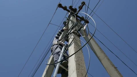 Electricity work, man repairs electric pole wearing all the safety equipment Stock Footage 148047752