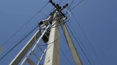 Electricity work, man repairs electric pole wearing all the safety equipment Stock Footage 149111756
