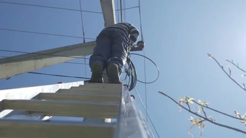 Electricity work, man repairs electric pole wearing all the safety equipment Stock Footage 150090006