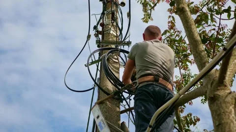 Electricity work, man repairs electric pole wearing all the safety equipment Stock Footage 156595543