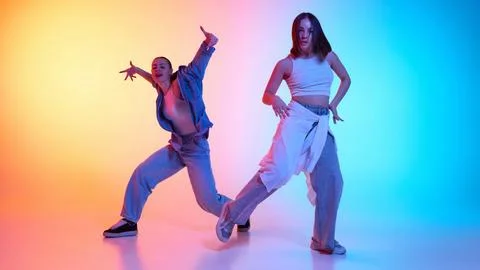 Electrifying hip hop performance by two dancers in urban fashion against neon Stock Photos