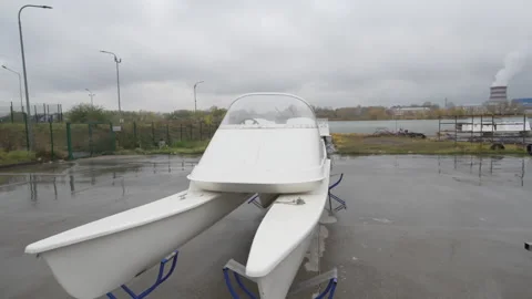 Electro catamaran rests on wet parking under cloudy sky Stock Footage 318737783