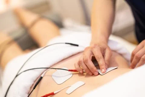 Electro stimulation in physical therapy to a young woman Stock Photos
