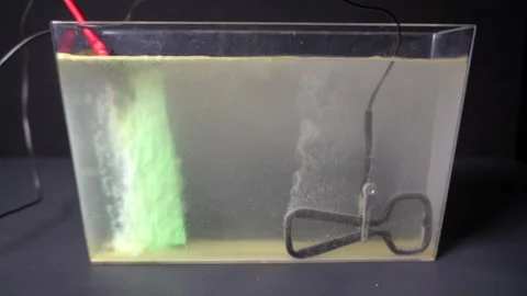 Electrolytic plating in small plastic tank. Science project. Stock Footage 320465614