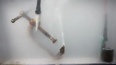 Electrolytic reduction (electrolysis) forms bubbles as it removes rust from Stock Footage 318519719