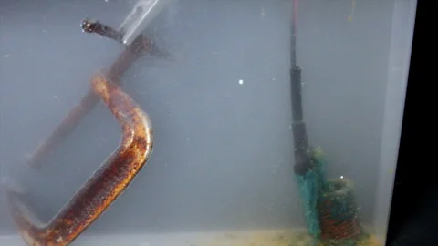 Electrolytic reduction tank with negative electric charge on c-clamp to clean Stock Footage 318604392