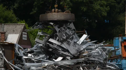 Electromagnet on crane sorting scrap metal at scrapyard Stock Footage 25596790