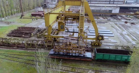 Electromagnetic crane moving metal sheets in steel yard. Gantry crane lifting Stock Footage 317100274
