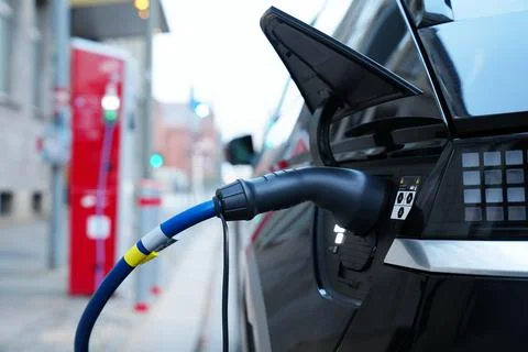 Electromobile charging plug is inserted into vehicle charging socket. Stock Photos