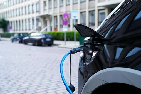 Electromobile charging plug is inserted into vehicle charging socket. Stock Photos