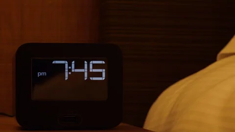 Electronic alarm clock stands on a bedside table in the room. Stock Footage 252787674