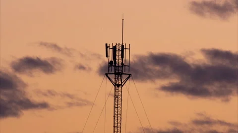 Electronic antenna with clouds and orange sky background. Stock Footage 258194757