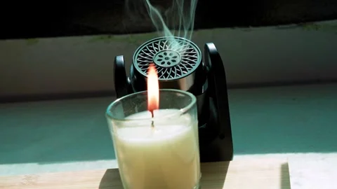 Electronic Aroma Diffuser And Lit Glass Candle Stock Footage 346056675