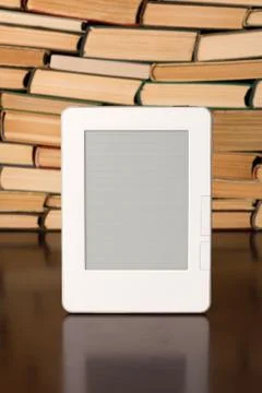 Electronic book on background of regular old books Stock Photos