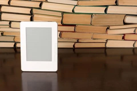 Electronic book on background of regular old books Stock Photos