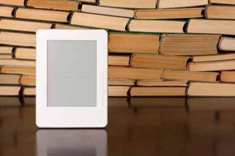 Electronic book on background of regular old books Stock Photos