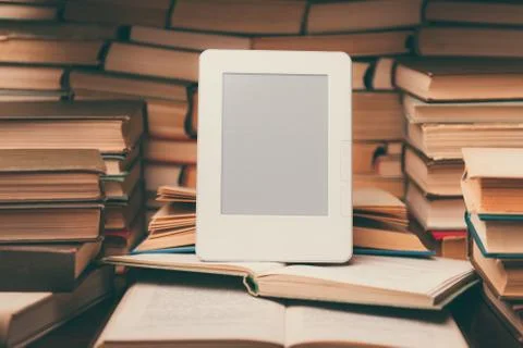 Electronic book on background of regular old books Stock Photos