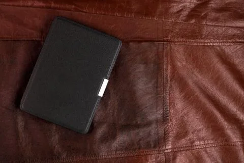 Electronic book in the case on leather background Stock Photos
